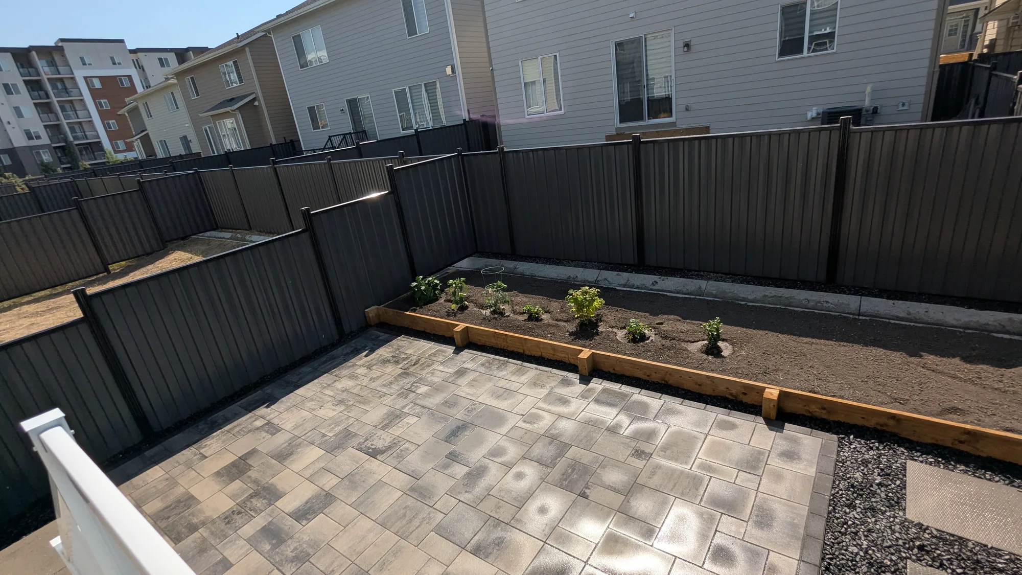Completed Calgary-area backyard patio with pavers, raised garden bed and privacy fencing.