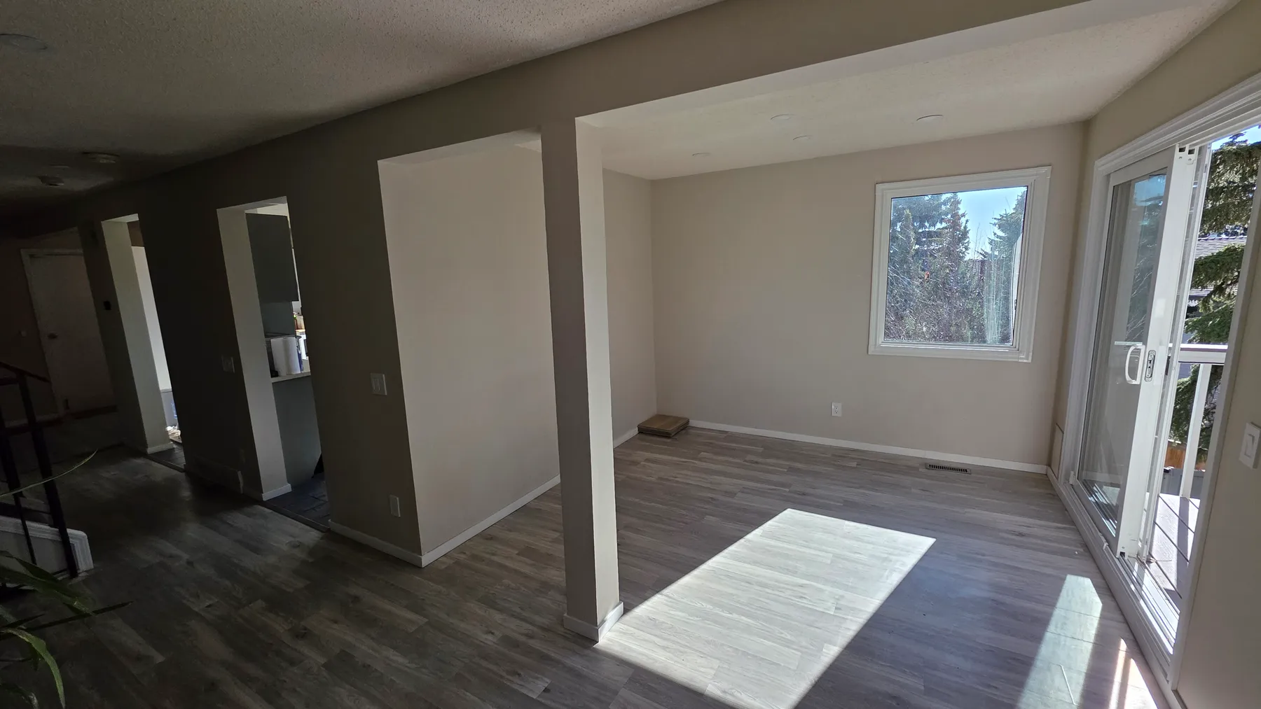 Original interior layout with wall sections dividing the living area from a room with a window and sliding patio door.