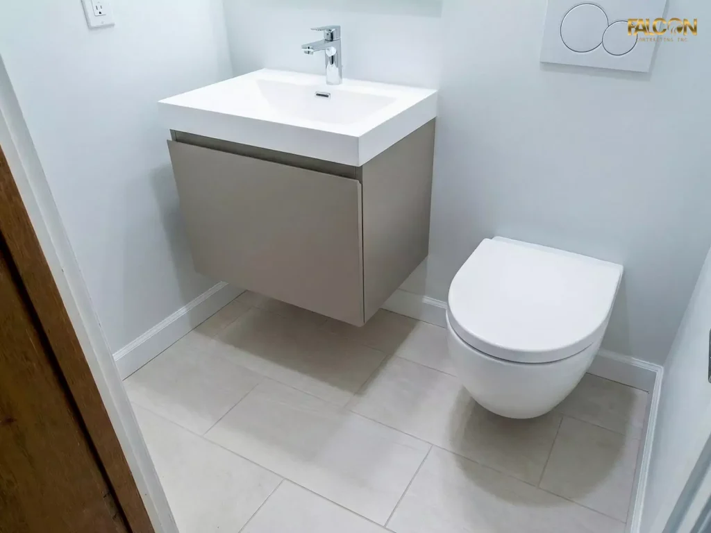 The same small bathroom renovated with a compact floating vanity and a wall-mounted toilet, revealing the tiled floor underneath and creating a sense of more space.
