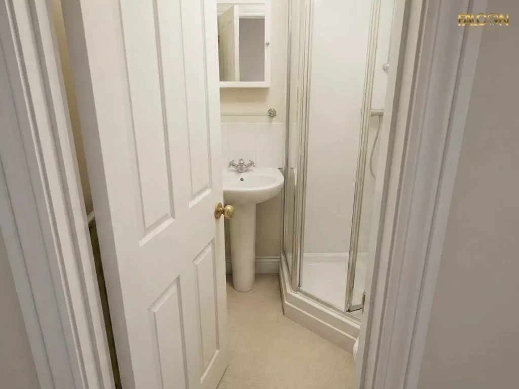 A small bathroom with a traditional swinging door opened inwards, consuming valuable floor space and making the room feel cramped.