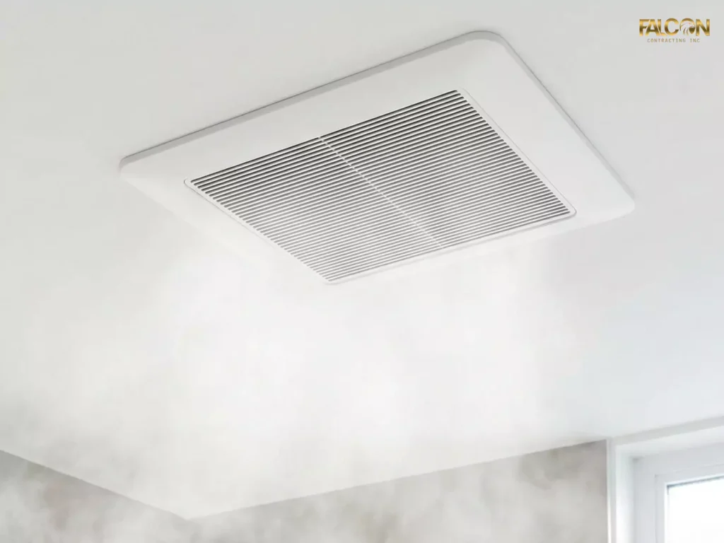 A close-up of a modern, high-CFM exhaust fan installed in a bathroom ceiling, effectively pulling steam from a shower.